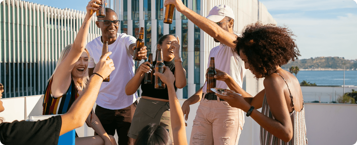 Friends celebrating together on a sunny terrace overlooking the water